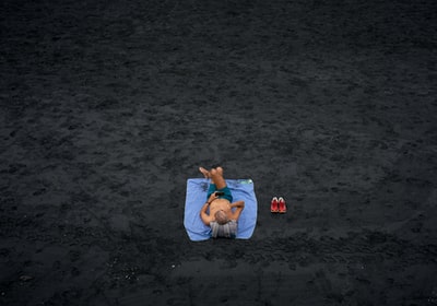 赤膊的男人躺在蓝色的野餐垫
